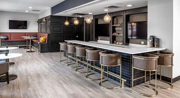 A large bar with stools in a lobby of a restaurant